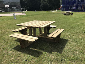 table d'exterieur en bois carré avec quatre banc intégrés