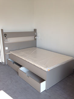 lit simple avec double tiroir de rangement intégrés ainsi qu'une tablette de nuit, deux lumière et une prise dans la tête de lit